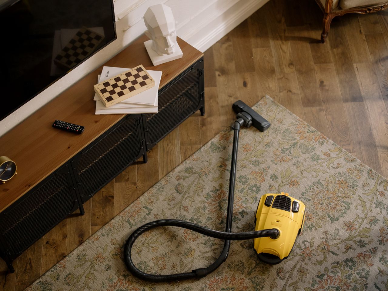 about-01 Warm living room scene featuring a yellow vacuum on a floral carpet with a vintage vibe.